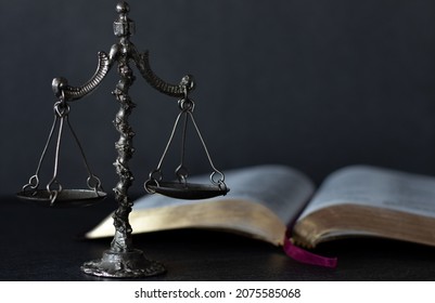 Law And Justice Christian Biblical Concept. Old Ancient Vintage Weighing Scale Balance With Open Holy Bible Book With A Dark Background. God Jesus Christ Judges Justly On Judgement Day. A Close-up.