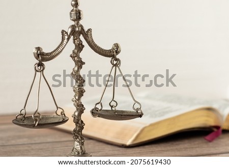 Law and justice Christian biblical concept. Old ancient vintage weighing scale balance with open Holy Bible Book with white background. God Jesus Christ Righteous Judge on Judgement Day. A close-up.