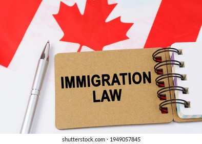 Law And Justice Concept. Against The Background Of The Flag Of Canada Lies A Notebook With The Inscription - IMMIGRATION LAW