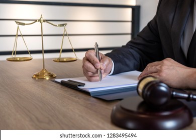 Rechtsanwalt und Rechtsanwalt, männlicher Rechtsanwalt oder Notar, der an Dokumenten arbeitet und über den wichtigen Fall in der Anwaltskanzlei berichtet.