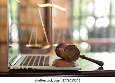 Law Legal Technology Concept.  Judge Gavel On Computer With Scales Of Justice On Desk Of Lawyer.