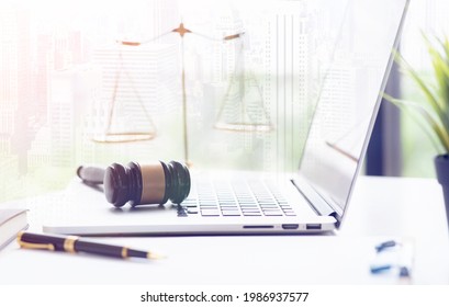 Law Legal Technology Concept. Judge Gavel On Computer With Scales Of Justice On Desk Of Lawyer.