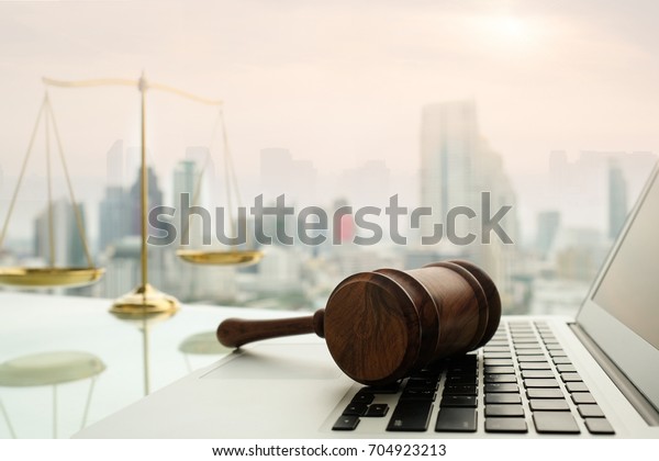 law legal technology concept. \
judge gavel on computer with scales of justice on desk of\
lawyer.