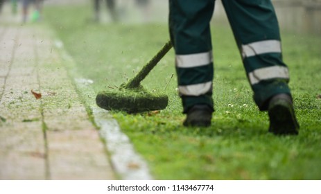 Law Mower Man Trimming Grass In The City