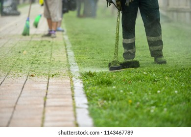 Law Mower Man Trimming Grass In The City