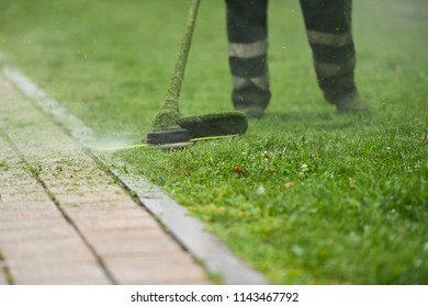 Law Mower Man Trimming Grass In The City