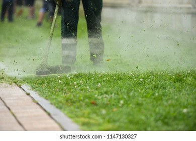 Law Mower Man Trimming Grass In The City