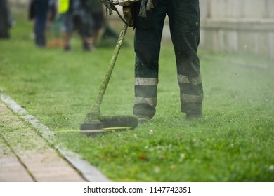 Law Mower Man Trimming Grass In The City