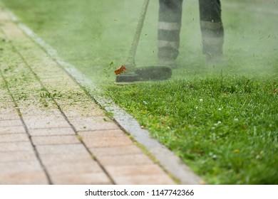 Law Mower Man Trimming Grass In The City