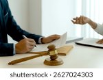In the law office  businessman and businesswoman work for clients to fight lawsuits in court or prepare legal documents for the company on their desks.