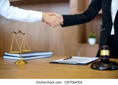 in Law office, Judge woman gavel with Justice lawyers having meeting with team  at law firm in background. Hand shake Concepts of law. 