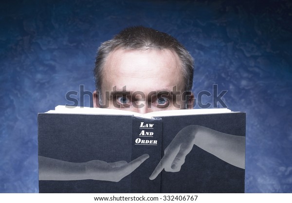 Law and order written on the cover of the book,\
mature man being focused and hooked by book, reading open book, man\
behind book.