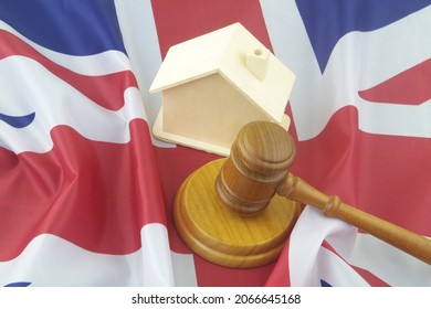 Law And Real Estate Business In UK. Judge Gavel With Wooden House Model On British Flag.