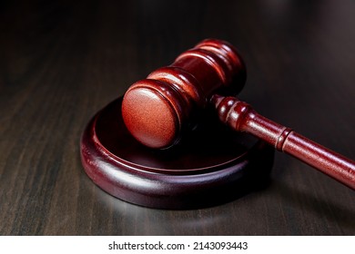 Law theme. Court of law trial in session. Judge gavel on wooden table in lawyer office or court session. Mallet of judge on dark background. Justice human rights concept
