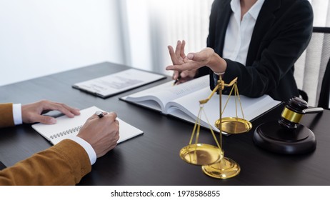 law,libra scale and hammer on the table, 2 lawyers are discussing about legal provision, law matters determination, open hand. - Shutterstock ID 1978586855