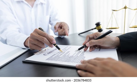 law,libra scale and hammer on the table, 2 lawyers are discussing about contract paper, law matters determination, pointing. - Shutterstock ID 2036784833