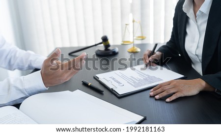 law,libra scale and hammer on the table, 2 lawyers are discussing about contract paper, law matters determination, open hand.