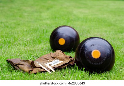 Lawn Bowls. Two Wooden Bowling Balls On Freshly Cut Grass With Measuring Device And Leather Cloth.