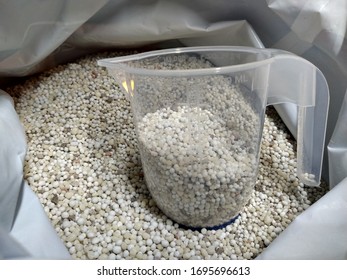 Lawn Fertilizer Granules In A Bag With Measuring Jug