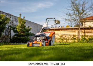 Lawn Mover On Green Grass In Modern Garden. Machine For Cutting Lawns.