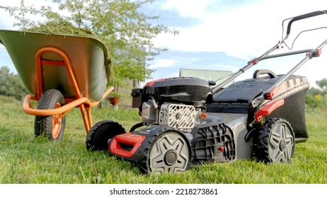 Lawn Mover On Green Grass In Modern Garden. Machine For Cutting Lawns.