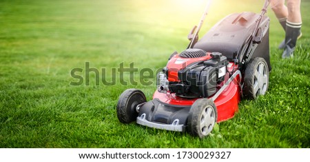 Lawn mover on green grass in modern garden. Machine for cutting lawns. Stockfoto © 