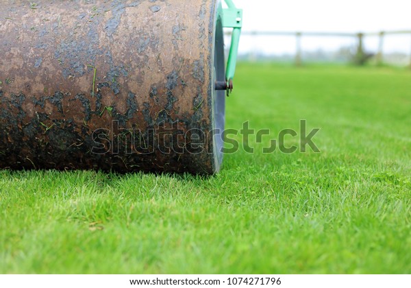 Lawn Roller Rolling Out Uneven Ground As\
Part Of Garden\
Maintenance.