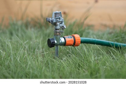 Lawn Sprinkler In Green Grass Switched Off.