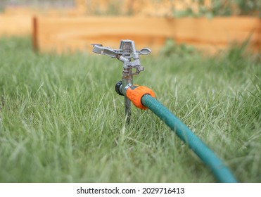 Lawn Sprinkler In Green Grass Turned Off In Summer.