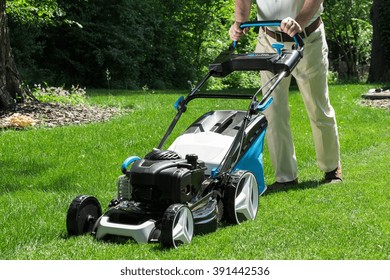 Lawnmower is being used by gardener for mowing grass