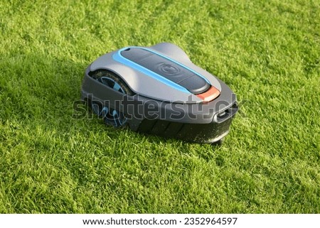 The lawnmower robot mows the grass in the garden.
