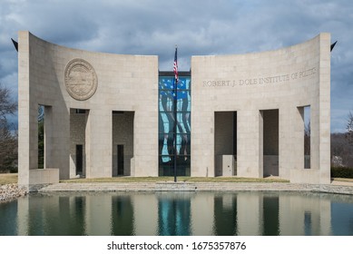 Lawrence, KS / United States of America-March 12th, 2020: Robert J Dole Institute of Politics.  Stone building with American flag, and reflecting pond in front, near KU campus, next to the Lied Center