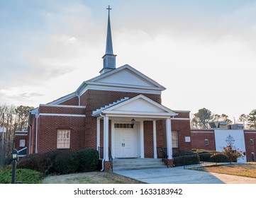 Lawrenceville, GA / USA - January 30 2020: Front view of Central Baptist Church,showing steeple and entrance doors, with church insignia on wall to the right of picture.