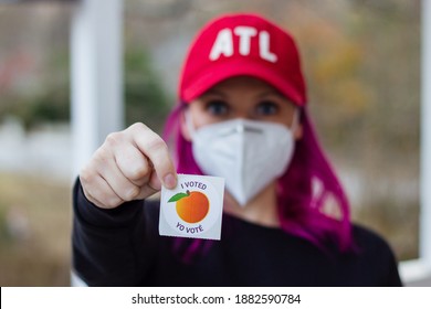 Lawrenceville, Georgia | United States - December 26 2020: A Georgia Voter Wearing A Mask Holds Up Her 