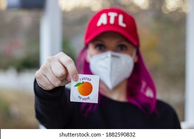 Lawrenceville, Georgia | United States - December 26 2020: A Georgia Voter Wearing A Mask Holds Up Her 