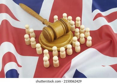 Laws And Court In UK Concept. Many Wooden Figures As People, British Flag And Judge Gavel.