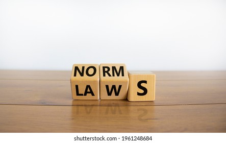 Laws or norms symbol. Turned cubes and changed the word 'norms' to 'laws'. Beautiful wooden table, white background, copy space. Business and laws or norms concept.