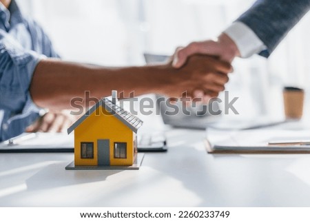 Lawsuits against Real estate agent and realtor general liability insurance businessman professional discussing and consultant with house toy model building shaking hands after sign a contract