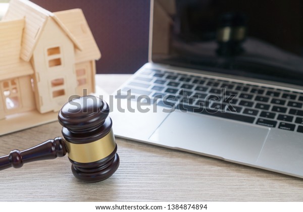 Lawyer business real estate property agent, home\
loan or divorce. Concept of Conflict lawsuit from not paying home\
debt, therefore requiring judgment prosecution. Judge hammer with\
house on Computer