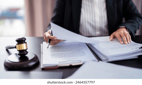 Lawyer businesswoman holding document to reading lawsuit and checking about financial business data while analysis about legislation agreement and terms data of business contract in law firm. - Powered by Shutterstock