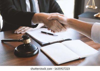 Lawyer consult hands shaking with client in courtroom. - Shutterstock ID 1635927223