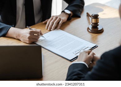 Lawyer is explaining the terms of the legal contract document and asking the client to sign it properly. Legal counsel and legal proceedings consulting services.