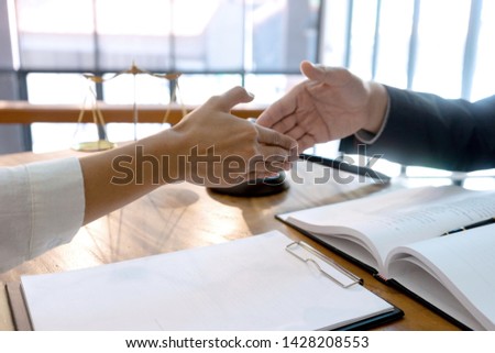Lawyer or judge  with gavel and balance handshake with client or customer about agreement how to  use arbitration       handshake