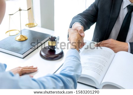 Lawyer or judge  with gavel and balance handshake with client or customer about agreement how to  use arbitration