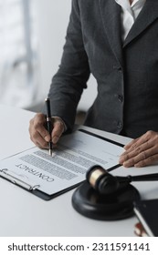 Lawyer or legal advisor reading restriction law advising corporate business planning guidelines, taxation, contract signing, legality and justice concept. - Shutterstock ID 2311591141