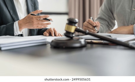 Lawyer Legal counsel presents to the client a signed contract with gavel and legal law. justice and lawyer Business partnership meeting concept. - Powered by Shutterstock