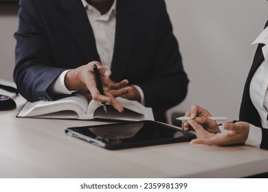 Lawyer meeting contact us concept: Lawyer businessman and woman working together with law book at desk in office, justice and law, attorney. - Shutterstock ID 2359981399