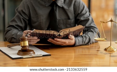 Lawyer is in the office, he is reading legal information to use to defend the case against the client, he admits to the client in a fraud case from a company employee. Lawyer Concept and Justice Law.