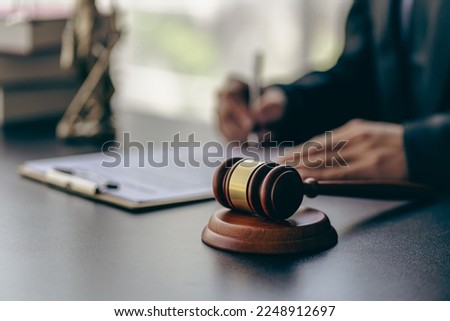 Lawyer office male working with hammer and scales with document, contract, legal adviser concept.