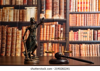 Lawyer Office. Statue Of Justice, Scales And Judge's Gavel Against The Backdrop Of A Wall Of Books Or A Library . Legal Law, Advice And Justice Concept